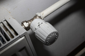 White thermostatic head on the battery. Heat regulation in the house