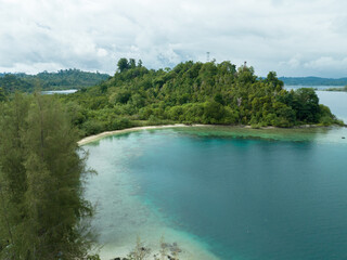 Obraz premium An aerial view of a tropical island with white sand beaches and turquoise waters. A typical tropical island scene