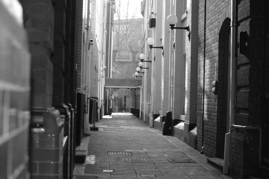 Fototapeta Black and white photo of a narrow city alley way 