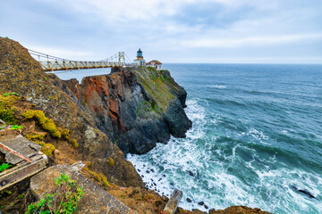 Point Bonita Lighthouse on rugged cliffs above the Pacific Ocean in Marin Headlands, California. Iconic coastal landmark near Highway 1, with crashing waves and dramatic sea views