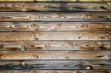 Wooden background. Texture of old weathered boards with pronounced fibers and knots.