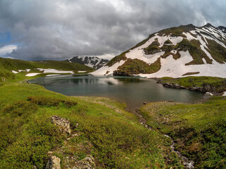 Picturesque a stream and a mountain lake.