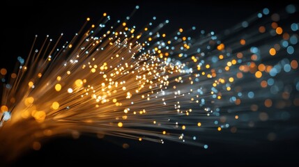Obraz premium Vibrant strands of fiber optics emit a mesmerizing glow in blue and orange hues against a dark backdrop, representing advancements in communication technology and innovation.