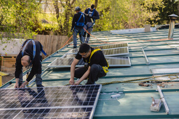 Workers installing solar panels on metal roof