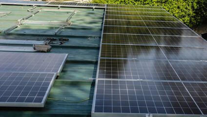 Installing solar panels on a green metal roof for renewable energy