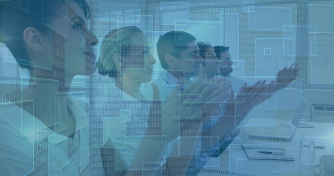 Applauding businesspeople sitting at office conference table, with laptop and binary code overlays