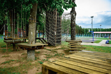 Rope obstacle track high in the trees, a rope course in an adventure park in a pine forest,...