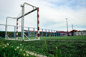 Outdoors football court with artificial turf. Football goal grass of a city stadium.