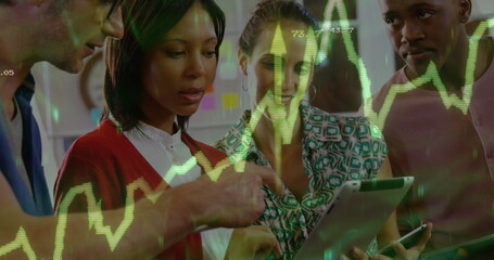 Reviewing green stock chart on tablet and phone by four colleagues in office space, sticky notes