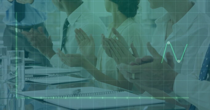 Clapping team in business attire at conference table with notebooks pens glasses and data overlay