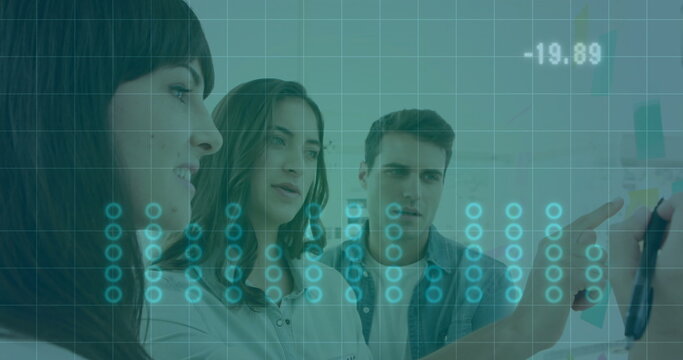 Leaning business casual colleagues reviewing diagrams on whiteboard in office with sticky notes