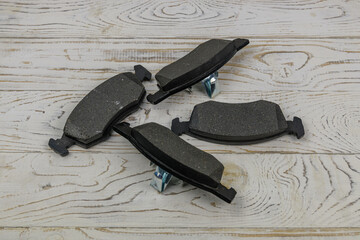 Disc brake shoes on a white wooden background
