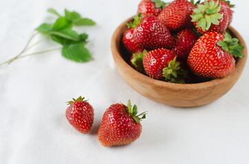 Ripe red strawberries in a ceramic bowl on a white background. Concept of summer berry harvest. Horizontal orientation. Selective focus. Copy space.