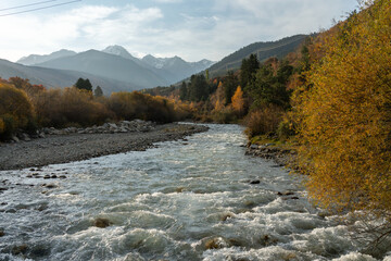 Karakol river flows through Autumn mountain scenery near outskirts of Karakol city in Kyrgyzstan