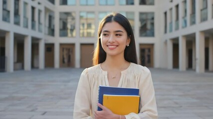 Smiling student portrait: happy college girl with books on university campus background photo shoot