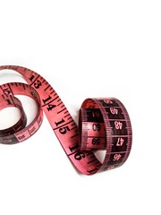 Pink measuring tape on a white background. Centimeter and inch tools for measuring the length or volume of the human body in the clothing industry.