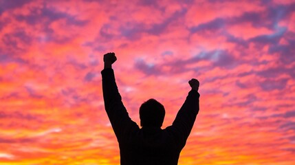 A backlit silhouette of a person standing with hands raised in the air, symbolizing strength, resilience, and self-empowerment against a powerful, vibrant sunset sky