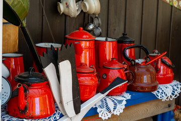 collection of vintage red enamel teapots and kettles arranged on a wooden table with decorative...