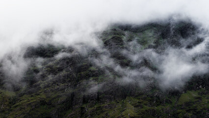 Cloud cover envelops the rough, rocky terrain of Carrauntoohill in County Kerry, Ireland. Low...