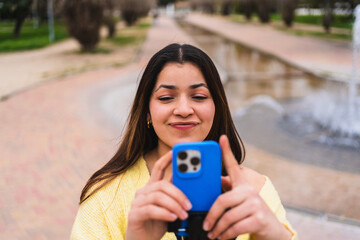 Young woman creating content for social media using a smartphone in a park