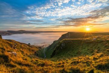 Winnats Pass at sunrise with cloud investion sunflare in the valley over Castleton. Peak District. England