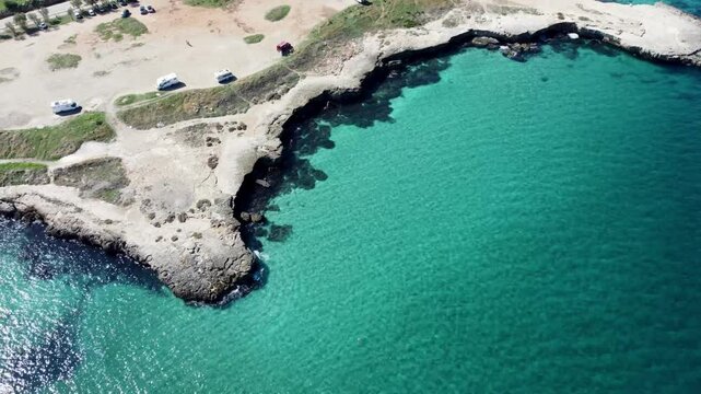 Drone footage of Monopoli, Italy &ndash; featuring turquoise sea, rocky coastline, sandy beach, and clear Adriatic waters in the Puglia region on a sunny day.