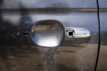 Broken car door handle with scratches.