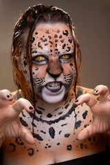 Woman with realistic artistic jaguar makeup, intense yellow eyes, detailed body paint and intense...