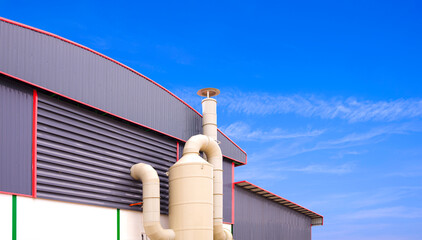 Wet scrubber exhaust air treatment system outside of production factory building against blue sky background, low angle view with copy space