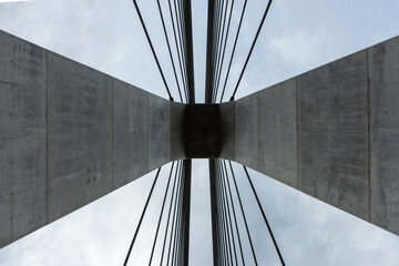 埼玉県秩父市の合角漣大橋の橋脚を真下から見上げた、抽象的な建築写真。コンクリートの主塔から放射状に伸びるケーブルが作り出す、幾何学的で力強いデザイン。近代的な土木技術やインフラ、アートを象徴するイメージ。

