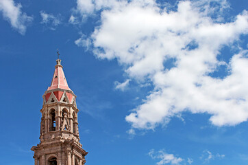Torres de iglesia en Aguascalientes sobre cielo azul con nubes blancas