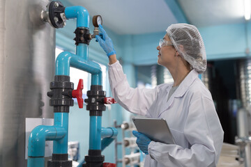 Drinking water manufacturers and production line. Water filter machine. Female worker inspecting...