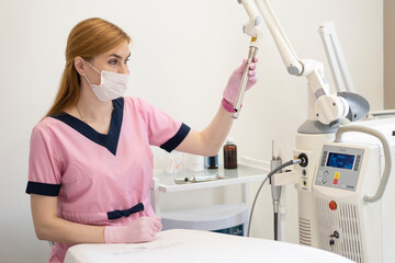  woman doctor of laser gynecology presses buttons on the screen of the Fotona laser device. Concept of laser technology in gynecology and women's health