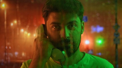 Portrait of Man Holding Telephone with Colorful Background Lights