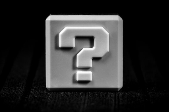 White square with question mark in dark room. Question mark on black background. Question concept