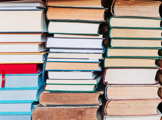 Stacks of old books arranged with page edges facing the camera. Neutral background, vintage feel,...