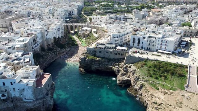 Drone footage of Polignano a Mare, Italy &ndash; featuring Lama Monachile beach, turquoise sea, dramatic cliffs, and scenic views of the Adriatic coastline in Puglia.