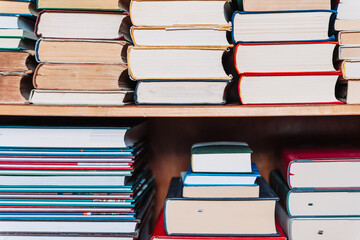 Stacks of old books arranged with page edges facing the camera. Neutral background, vintage feel,...