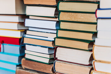 Stacks of old books arranged with page edges facing the camera. Neutral background, vintage feel,...