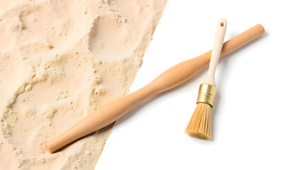 Wooden rolling pin and pastry brush resting on a light-colored flour surface, showcasing baking tools for culinary enthusiasts and home cooks in a kitchen setting
