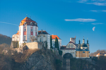 Vranov nad Dyji Chateau overlooking the Thaya river in Czech Republic with half moon in the blue sky