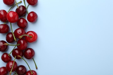 Fresh ripe cherries on light background, flat lay. Space for text