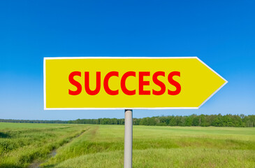 Success symbol. Concept word Success on beautiful yellow road sign. Beautiful blue sky green grass...