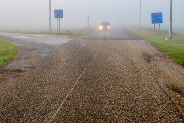 Car driving through dense fog at border crossing