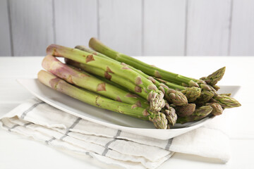 Fresh raw asparagus spears on white wooden table, closeup