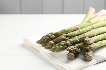 Fresh raw asparagus spears on white wooden table, closeup. Space for text