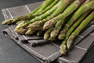 Fresh raw asparagus spears on black table, closeup