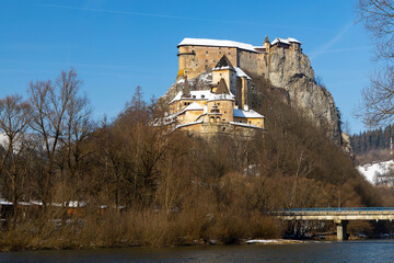 Oravsky Castle rising above Orava River in Slovakia during winter