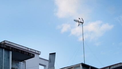 Rooftop antenna silhouette against blue sky, solitude and serenity, urban whispers, television...