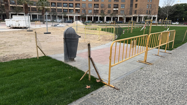 Urban construction site whispers future renewal, mesh fences guard dormant dreams; emblem of Urban Greening Day and Cleanup Week